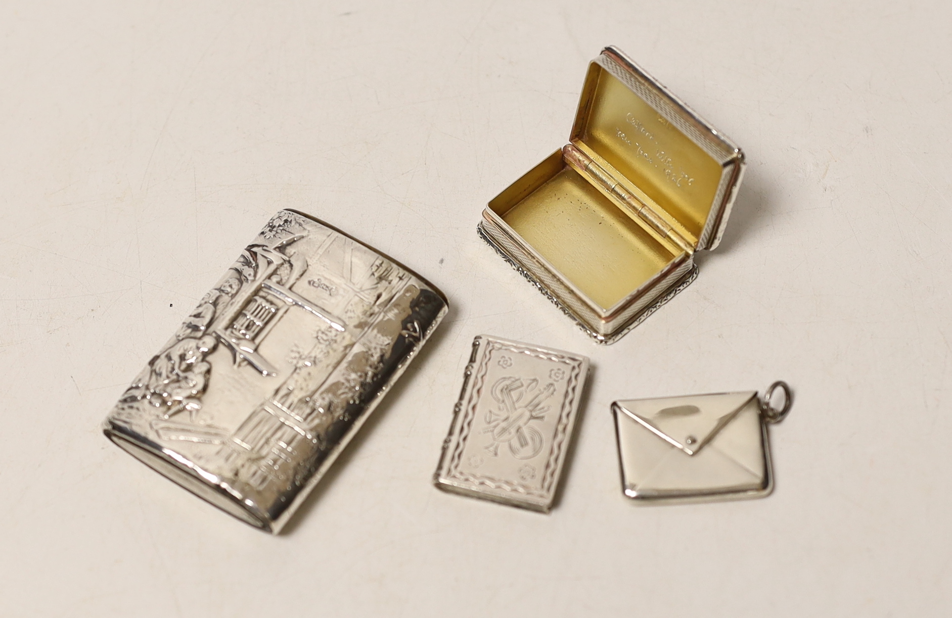 A modern silver snuff box, an Edwardian silver 'envelope' stamp case, a German 925 snuff box and an unusual antique white metal spinning fob seal case?